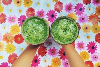 Directly above shot of person holding spinach juice in glasses