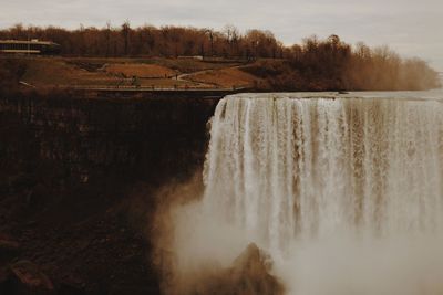 Scenic view of waterfall against sky