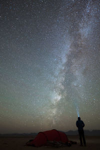 Silhouette man standing against star field at night