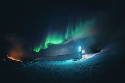 Rear view of man standing against sky at night