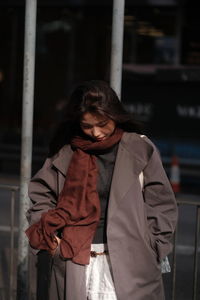 Portrait of young woman sitting on railing