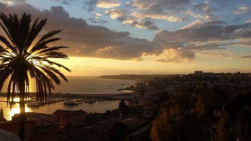 Panoramic view of sea and city buildings at sunset