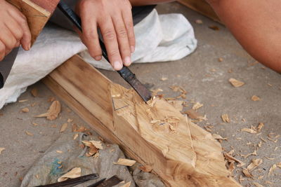 Cropped hands of carpenter carving wood