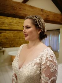 Close-up young woman in wedding dress standing at home