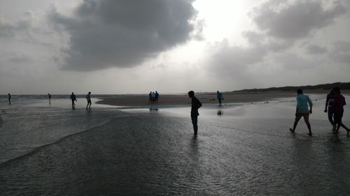 People at beach against sky