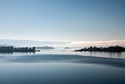 View of calm lake against clear blue sky