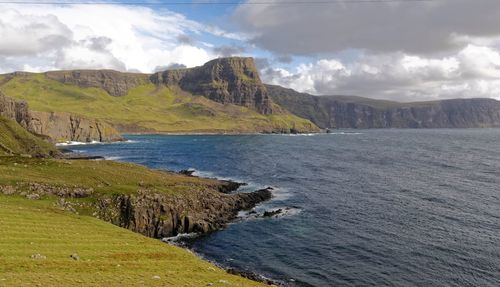 Scenic view of sea and mountains against sky