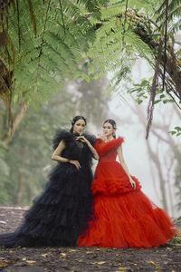 Portrait of smiling young woman standing in forest