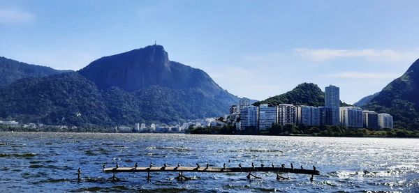 Scenic view of buildings by mountains against sky