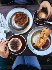 Midsection of friends having breakfast at table