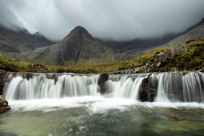 Scenic view of waterfall against sky