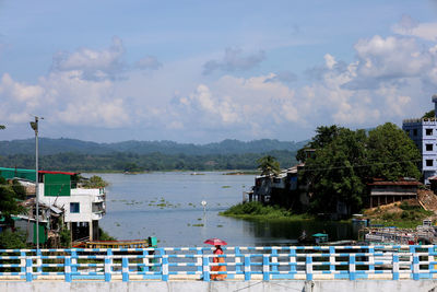 A woman crossing a bridge with an umbrella 