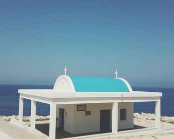 Built structure on beach against clear blue sky