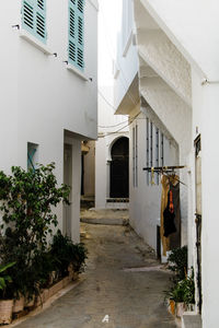 Woman standing on footpath by building