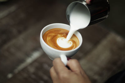 Cropped image of hand holding coffee cup