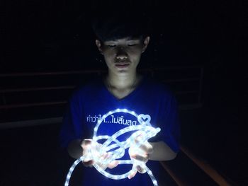 Young man wearing mask against black background