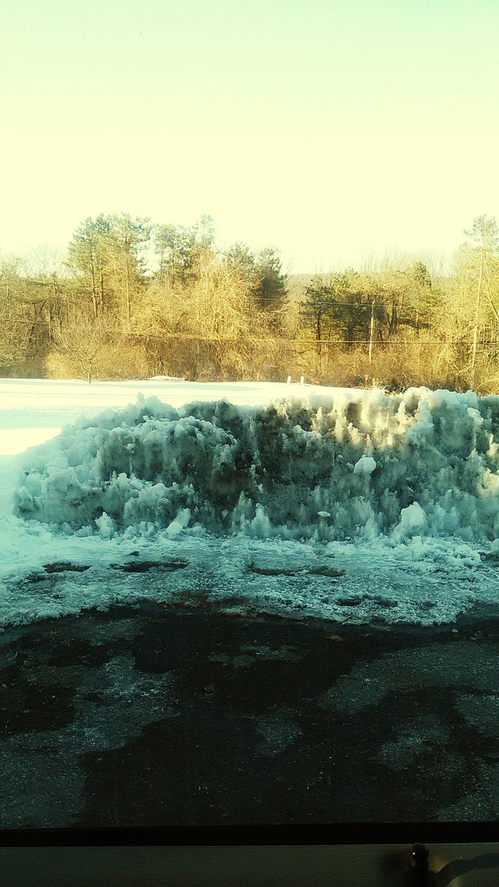 water, clear sky, nature, tranquil scene, tranquility, beauty in nature, tree, scenics, copy space, winter, sky, day, growth, outdoors, no people, motion, idyllic, snow, cold temperature, grass