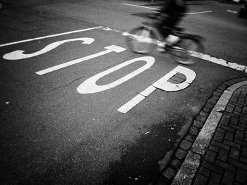 Blurred motion of bicycle moving over stop sign on asphalt