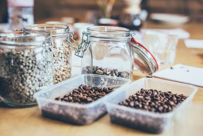 Roasted coffee beans in containers on table