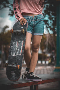 Low section of woman skateboarding