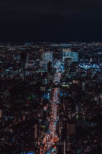 High angle view of illuminated cityscape against sky at night