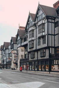 Street by buildings in city against sky