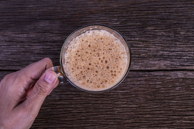 Directly above shot of hand holding coffee cup