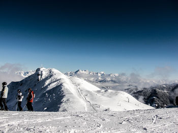 Tourists on snow covered mountain