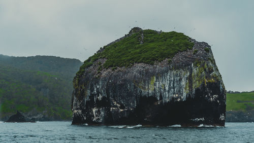 Scenic view of rock formation in sea against sky