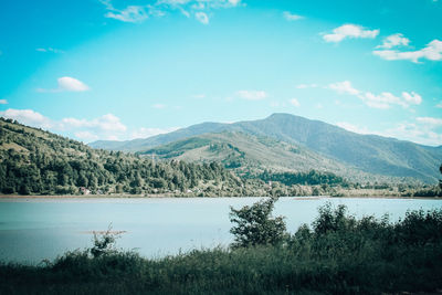 Scenic view of lake and mountains against sky