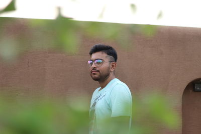 Portrait of young man wearing sunglasses standing outdoors