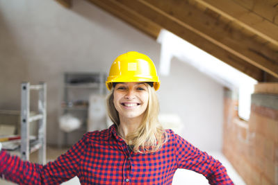 Portrait of smiling woman in helmet at construction site