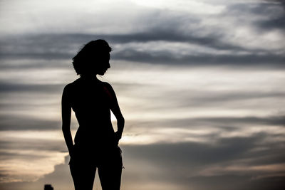 Low angle view of silhouette woman standing against sky