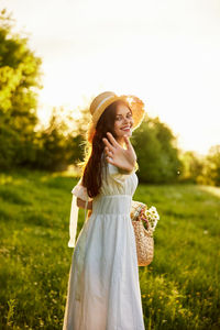 Portrait of young woman standing against trees