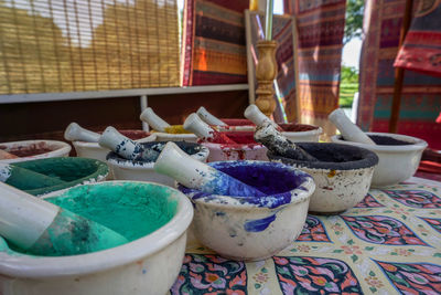 Close-up of powder paint in containers on table