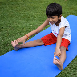 Asian smart kid doing yoga pose in the society park outdoor, children's yoga pose. the little boy