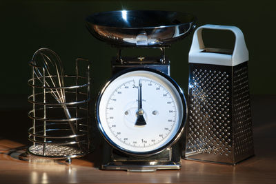 Close-up of weight scale with grater on table