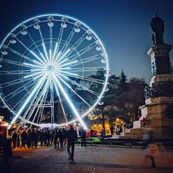 Illuminated ferris wheel in city at night