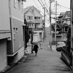 Rear view of person walking on street in city