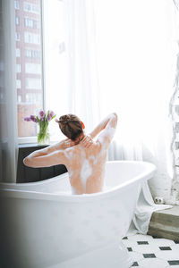 Young happy woman taking bath at home, treat yourself