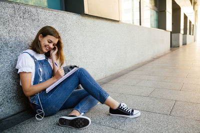 Full length of woman sitting on floor