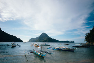 Boats moored on sea against sky