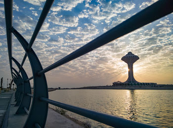 Statue in sea against cloudy sky