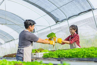 Woman holding food while standing by plants
