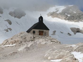 Building against mountain range during winter