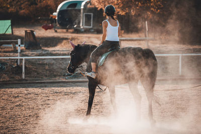 Full length of woman riding horse