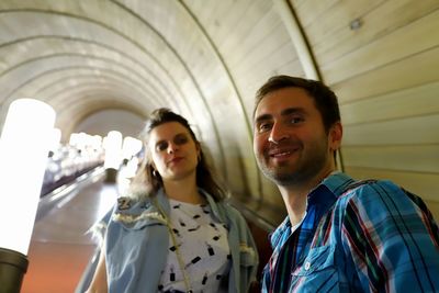 Portrait of smiling couple standing in subway station