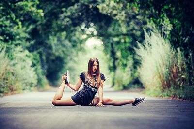 Rear view of woman sitting on tree