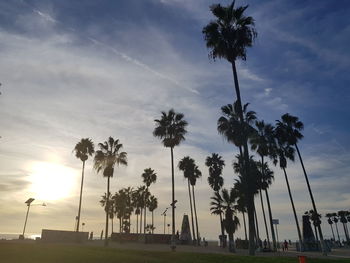 Silhouette palm trees against sky during sunset