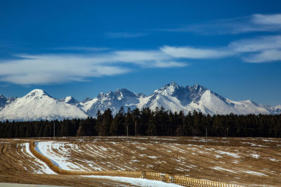 Scenic view of snowcapped mountains against blue sky